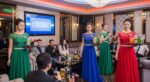包廂內身穿綠、藍、紅色禮服的女性