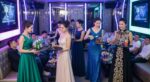 霓虹燈包廂內身穿禮服的女性端送飲料