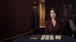 女性坐在深藍圓桌前，桌上空白卡片與手冊，面試前整理工作與薪資問題