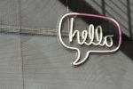 灰色牆面上的 hello 霓虹燈對話框