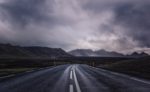 烏雲下延伸至遠山的柏油公路